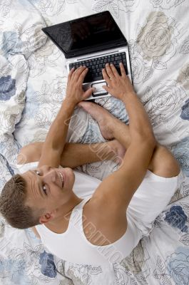 high angle view of smiling man working on laptop high angle view of smiling man working on laptop