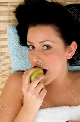 smiling woman eating apple in spa