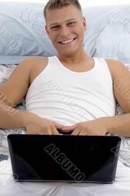 smiling guy posing with laptop
