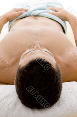 front view of man lying down for spa treatment front view of man lying down for spa treatment