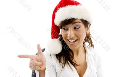 smiling businesswoman in christmas hat pointing si