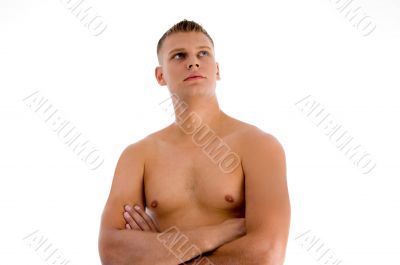 muscular man with crossed arms looking upward