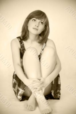 Young beautiful woman sitting on floor, sepia toned