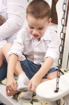 Adorable Young Boy Getting Socks On