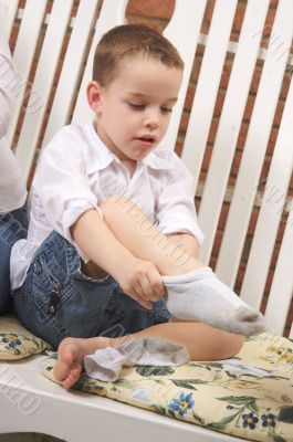 Adorable Young Boy Getting Socks On