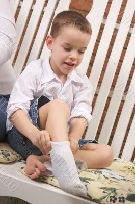 Adorable Young Boy Getting Socks On