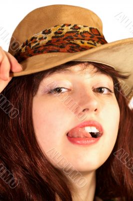 Young woman in hat shows tongue