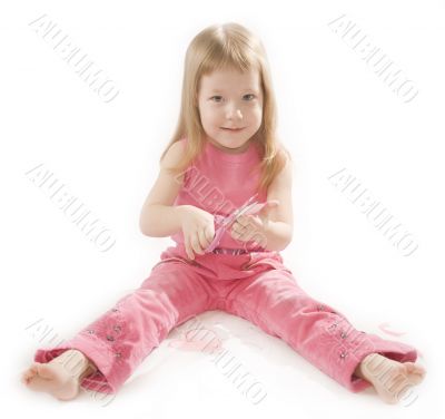 pretty small girl is cutting paper heart shape