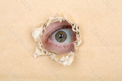Eye looking from a hole in a cardboard