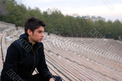 cool man sitting in stadium grandstands