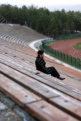 man sitting alone at stadium tribun man sitting alone at stadium tribun