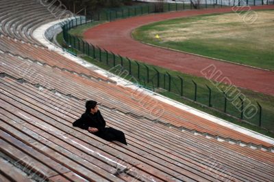 one man sitting alone in stadium grandstand one man sitting alone in stadium grandstand