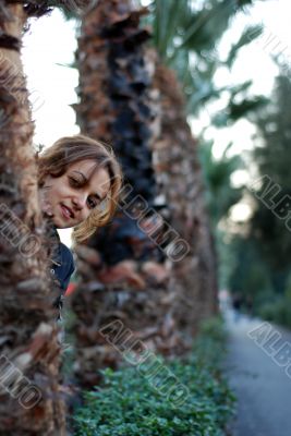 beautiful woman hiding between the trees