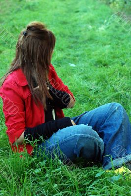 pretty woman sitting on grass playing with hairs