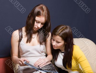 Two girls consider a picture album
