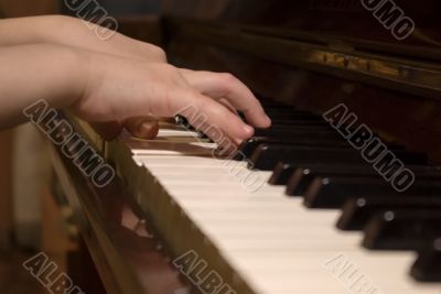 child`s hands on the piano roll
