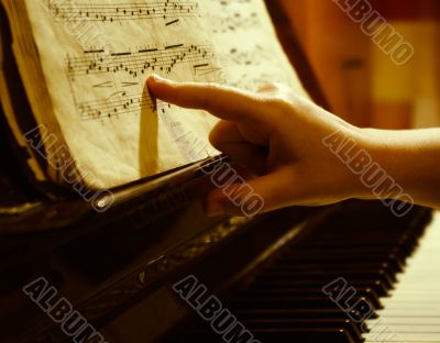 child finger at music sheet