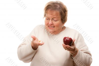 Confused Senior Woman Holding Apple and Vitamins