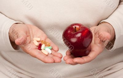 Senior Woman Holding Pills and Apple