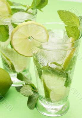 Two mojito cocktails on green background