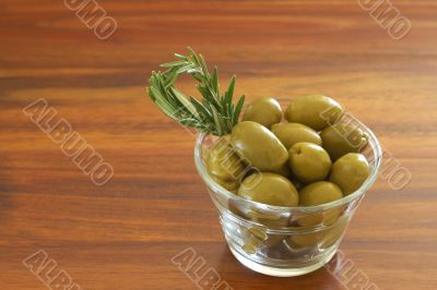 Single jar of green olives with rosemary
