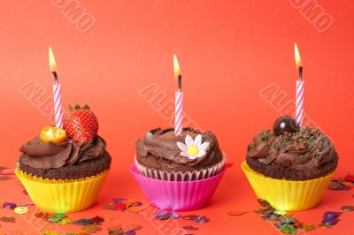 Miniature chocolate cupcakes with candles