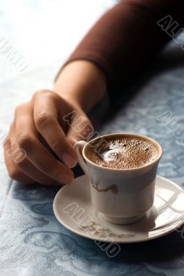 holding cup of coffee