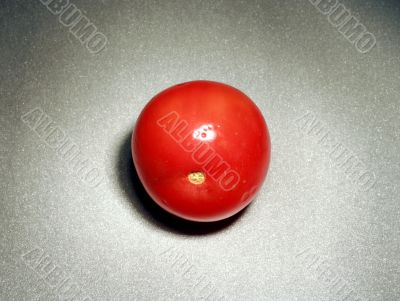 A single tomato on the table surface