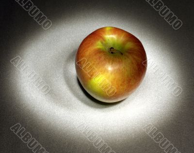 A red apple in the light circle