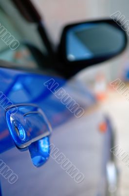 Right side mirror of shiny blue car