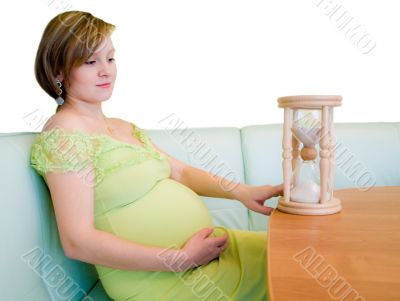 Pregnant woman looking on the hourglass