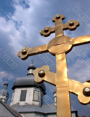 Huge golden christian cross near church