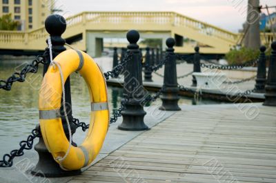 Yellow life buoy on fence Yellow life buoy on fence