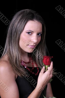 Beautiful young brunette woman with a red rose