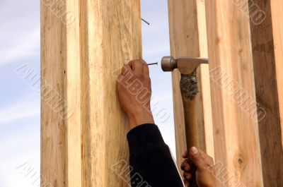 Hispanic carpenter pounding a nail