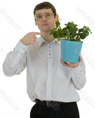 Man in spectacles showing on window plant