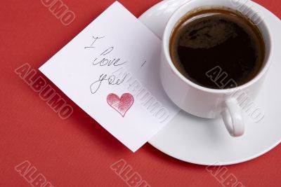 Cup with hot coffee and note