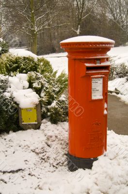 Traditional red British Post box in the snow