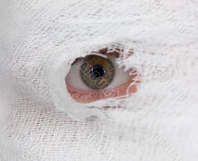 Eye looking on hole in bandage Eye looking on hole in bandage