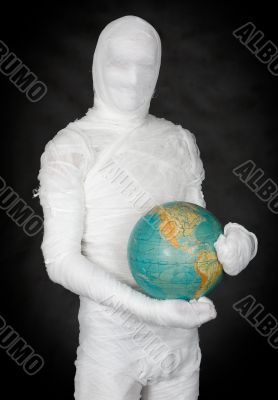 Man in costume mummy and terrestrial globe