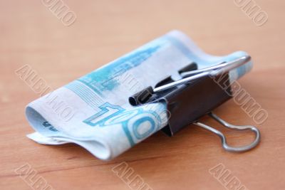 Clip with banknote on the wooden table