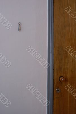 Wooden door and grey wall with a key