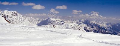 Snowy mountains in clouds with tints of blue