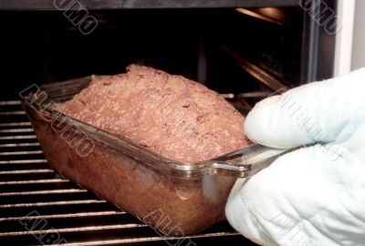 Taking out Dundee cake from oven