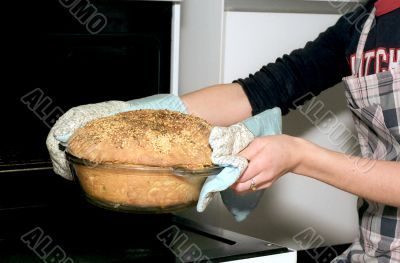 Taking out potato bread from oven