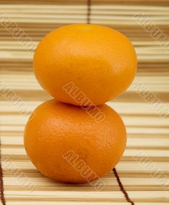 Two ripe mandarins on mat