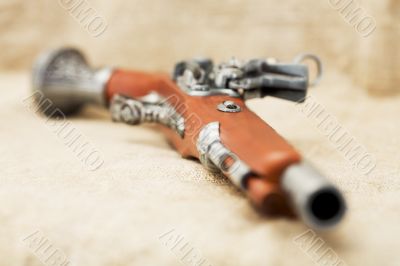 Ancient pistol on background canvas