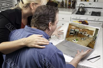 Couple In Kitchen Using Laptop - Home Improvement