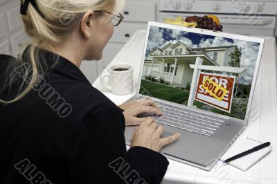 Woman In Kitchen Using Laptop for Real Estate