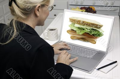 Woman In Kitchen Using Laptop - Food and Recipes